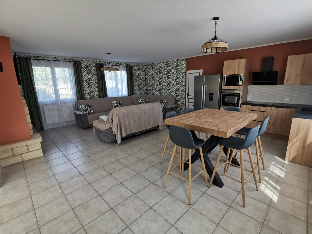 une cuisine et un salon avec une table et des chaises dans l'établissement Gîte Natura Bella, à Bressuire