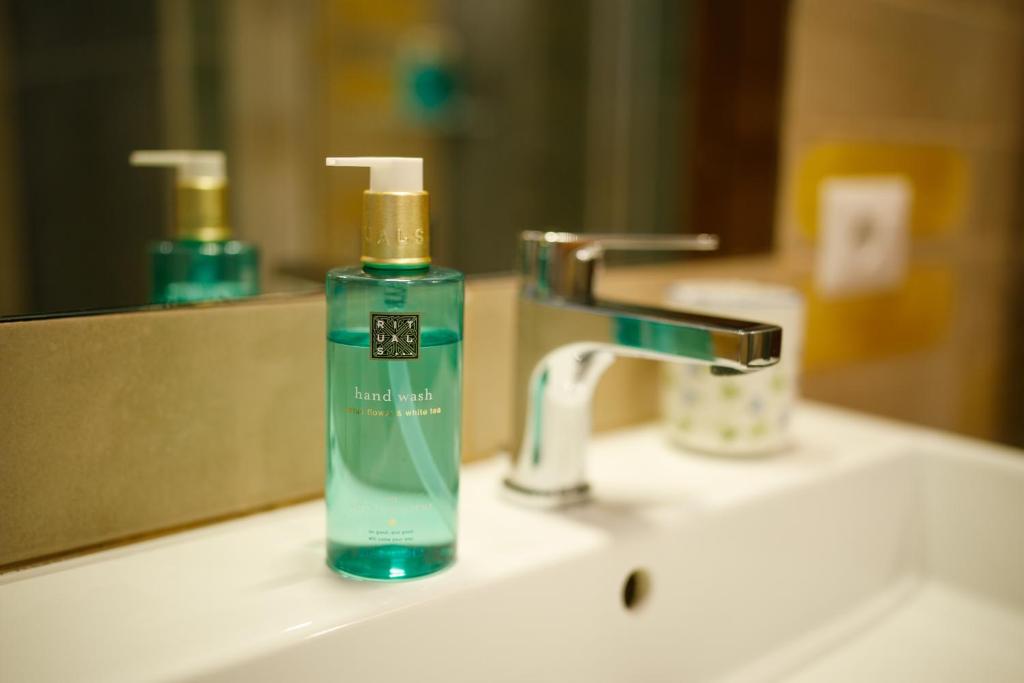 une bouteille de savon verte posée sur un lavabo de salle de bain dans l'établissement Villa Maredona, à Ascea