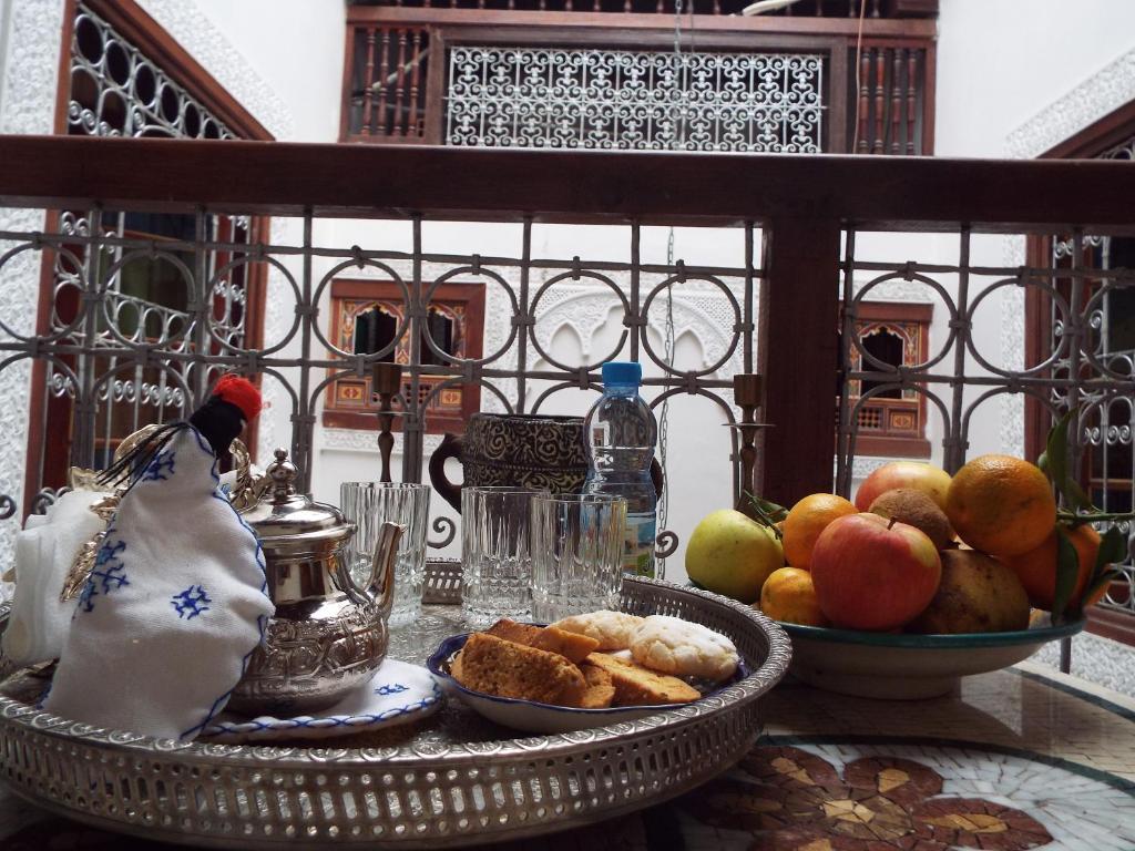 - une table avec un bol de fruits et une assiette de nourriture dans l'établissement Dar Fès Huda, à Fès