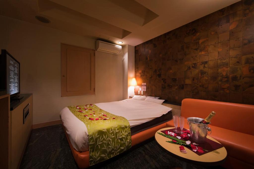 une chambre d'hôtel avec un lit, une table et un canapé dans l'établissement Hotel Will池袋 Adult Only, à Tokyo