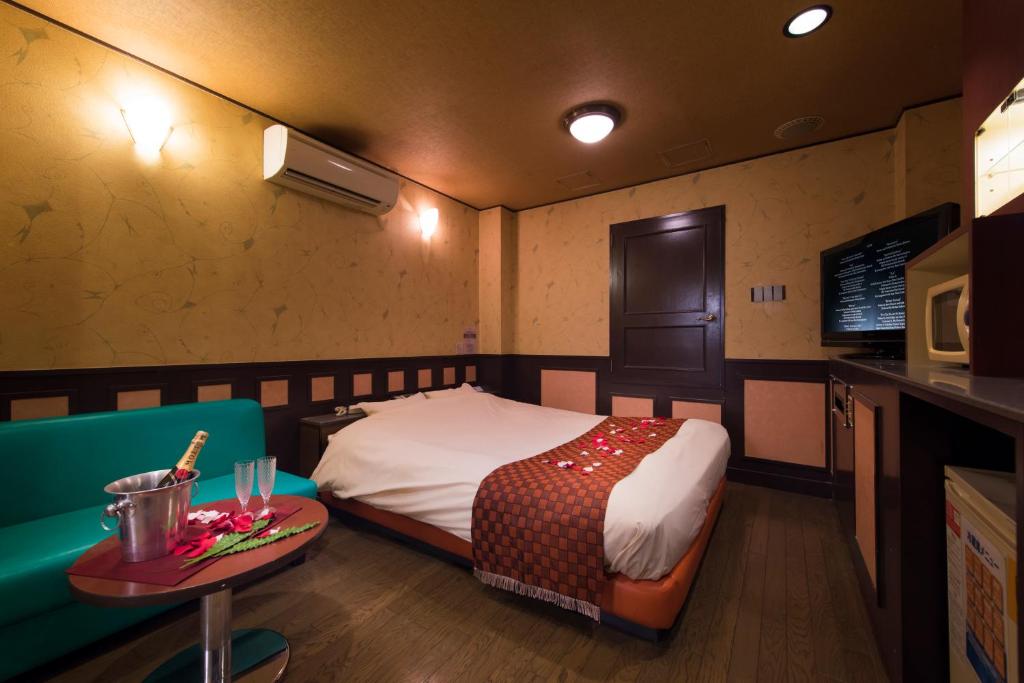 une chambre d'hôtel avec un lit et une table et une table sidx sidx dans l'établissement Hotel Will池袋 Adult Only, à Tokyo