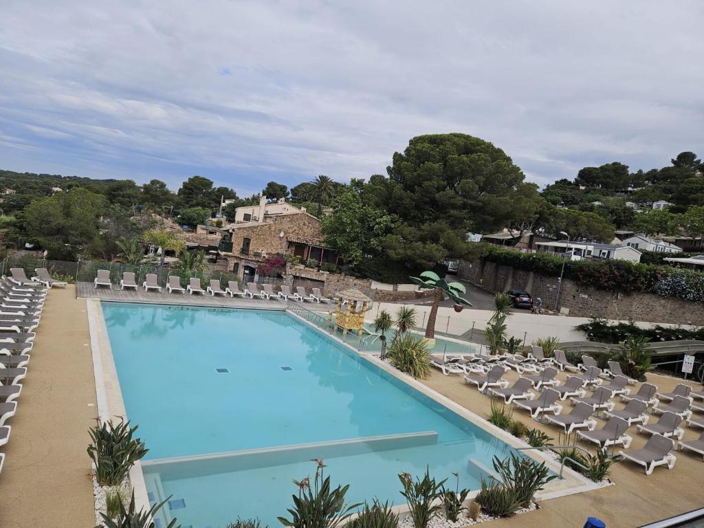 une grande piscine avec des chaises longues et un complexe hôtelier dans l'établissement Voltaire, à Saint-Raphaël