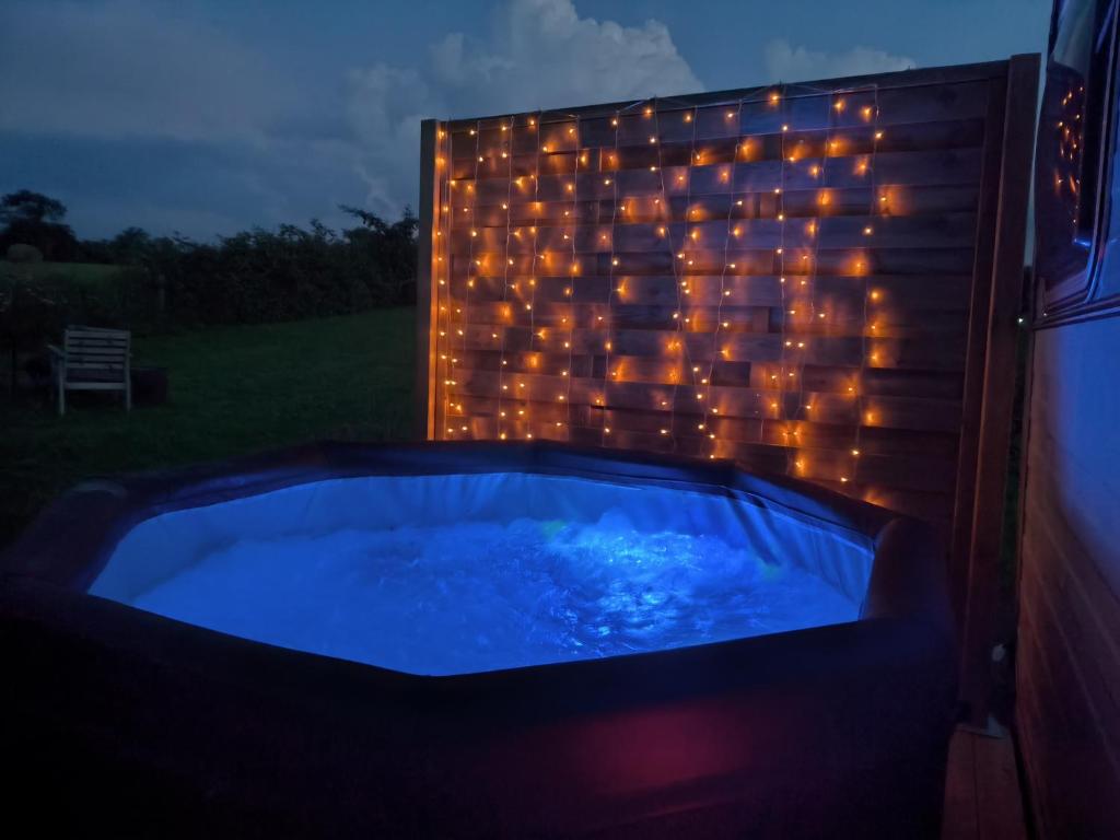 - un bain à remous avec des lumières dans la cour la nuit dans l'établissement Caravane Seventies avec jacuzzi, à Lapalisse 11 autres photos