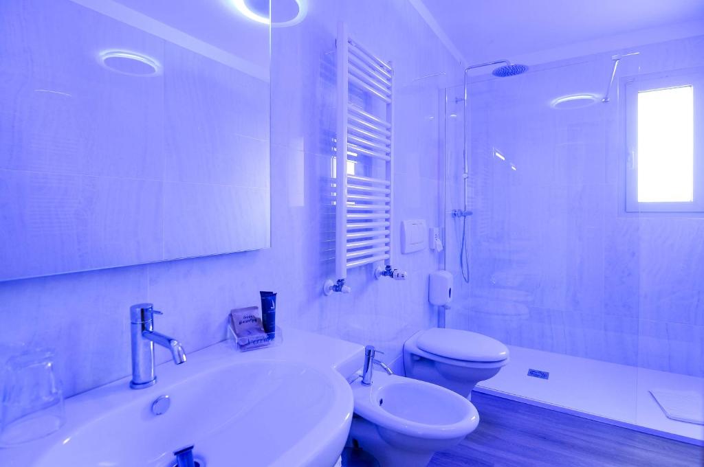 une salle de bain blanche avec un lavabo et des toilettes dans l'établissement Eco Hotel Cleofe, à Caorle