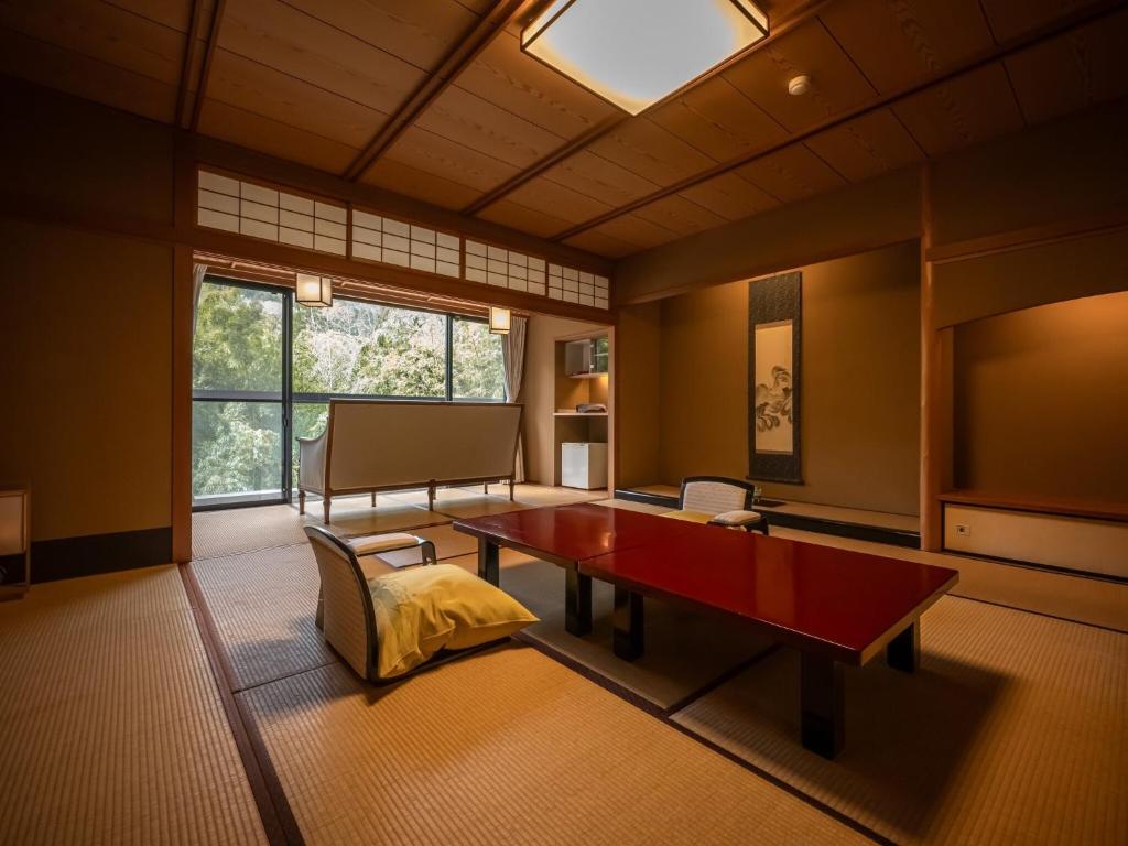 un salon avec une table et un canapé dans l'établissement Kuriya Yasohachi, à Kaga