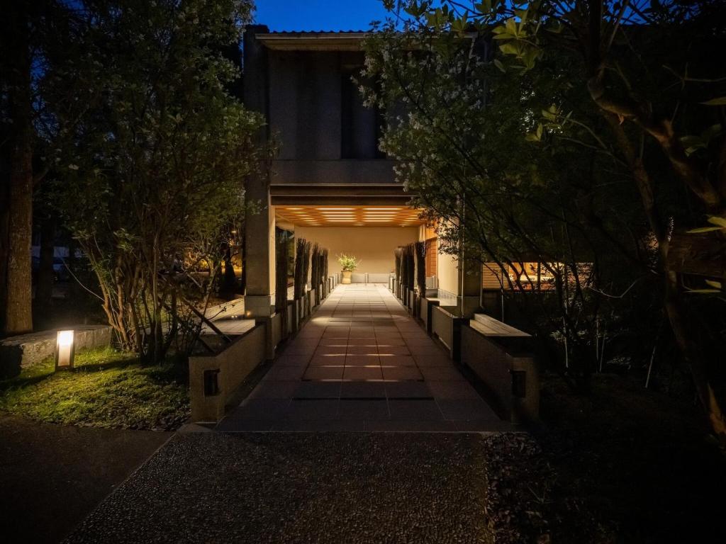 une passerelle menant à un bâtiment la nuit dans l'établissement Kuriya Yasohachi, à Kaga