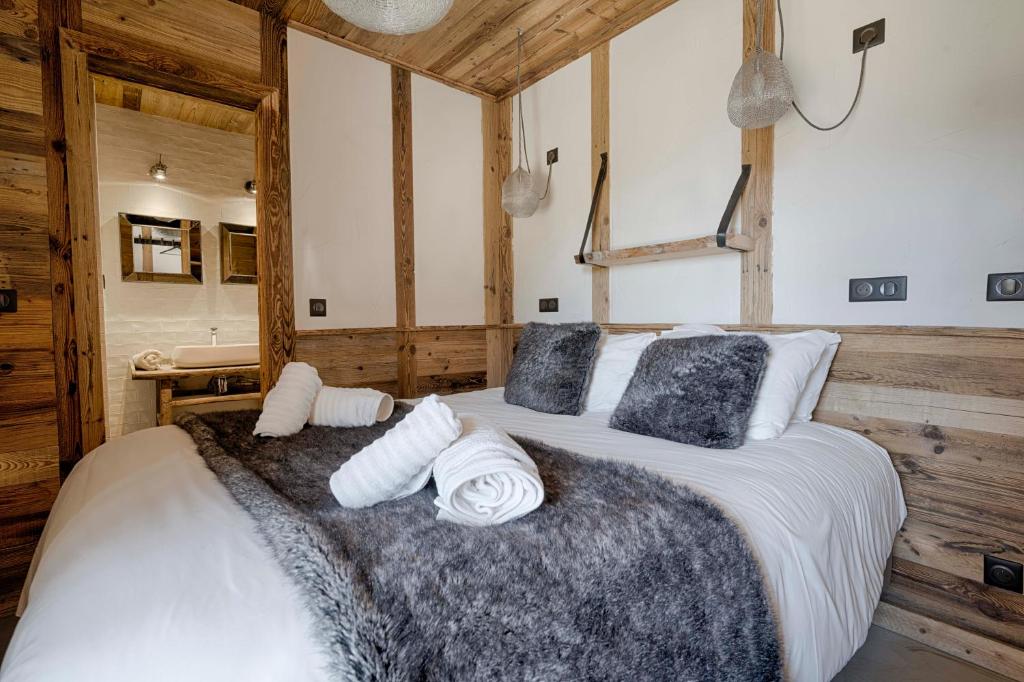 une chambre avec un grand lit avec des serviettes dessus dans l'établissement Chalet Le Perchoir, Spa, Sauna, sur les pistes, à Villard-Reculas