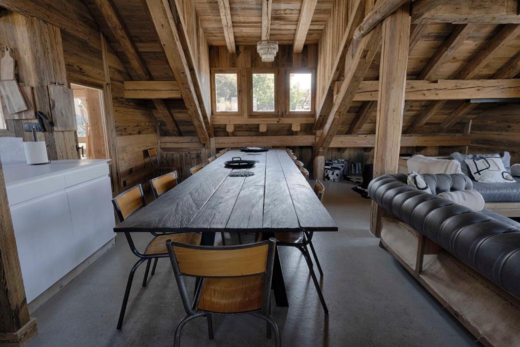 une grande table en bois et des chaises dans une pièce dans l'établissement Chalet Le Perchoir, Spa, Sauna, sur les pistes, à Villard-Reculas 37 autres photos
