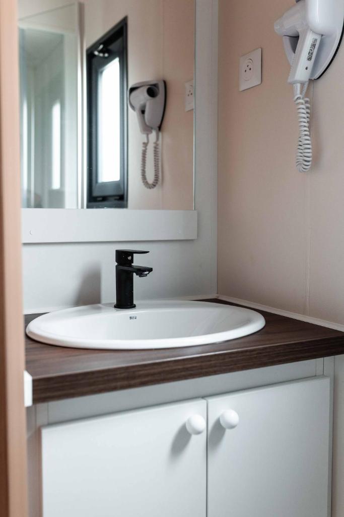 une salle de bain avec un lavabo et un miroir dans l'établissement Nova Lodges, à Grimaud