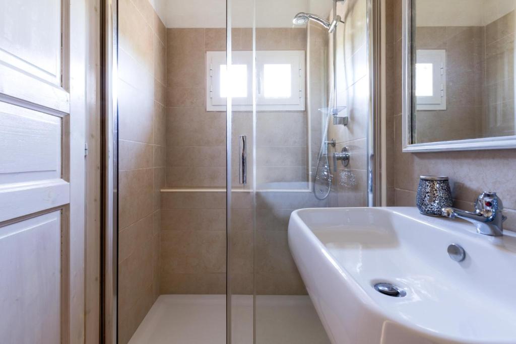 une salle de bain avec une douche et un lavabo et une douche dans l'établissement Trullo Il Cavaliere by BarbarHouse, à Padresergio
