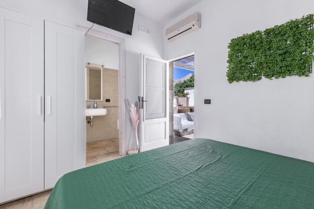 - une chambre avec un lit vert et une salle de bains dans l'établissement Trullo Il Cavaliere by BarbarHouse, à Padresergio