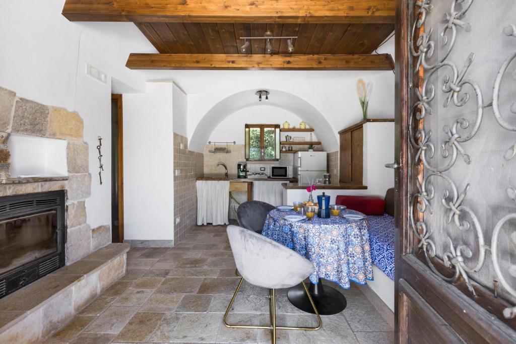 un salon avec une table et une cheminée dans l'établissement Trullo Il Cavaliere by BarbarHouse, à Padresergio