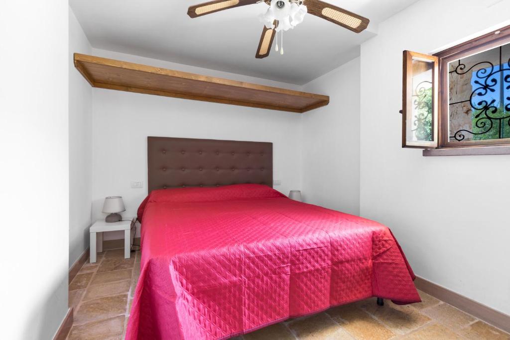 une chambre avec un lit avec un couvre-lit rose dans l'établissement Trullo Il Cavaliere by BarbarHouse, à Padresergio 27 autres photos