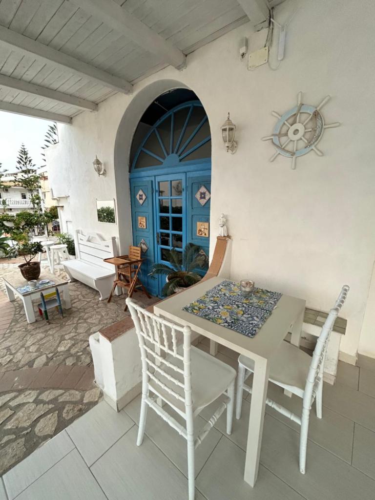 d'une terrasse avec une table et des chaises ainsi qu'une porte bleue. dans l'établissement La Porta del Mare, à Tropea