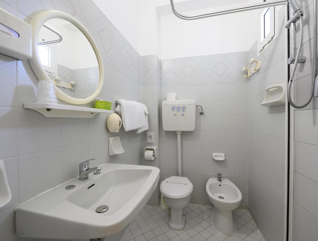 une salle de bain blanche avec un lavabo et des toilettes dans l'établissement Hotel St. Moritz, à Rimini