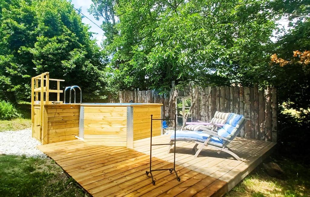 une terrasse en bois avec un banc et une chaise. dans l'établissement Gite Champêtre Drome Lorette, à Marsanne