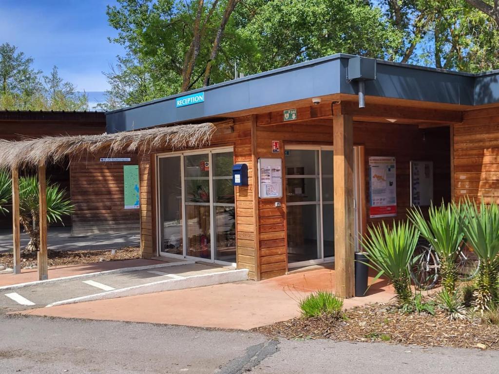 un bâtiment avec une enseigne sur la façade dans l'établissement Camping Le Val de Cesse, à Mirepeisset