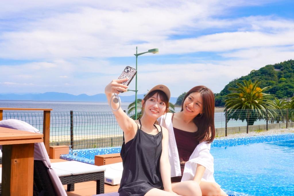 2 femmes assises à côté d'une piscine dans l'établissement Setouchi Island Stays Suo Oshima, à Suo Oshima