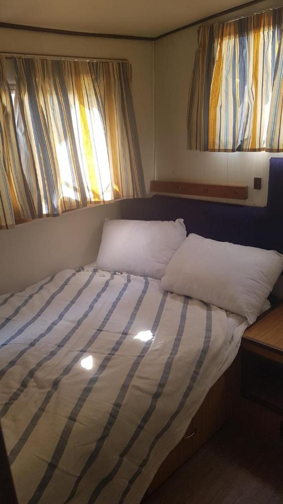 - un lit dans une chambre avec 2 fenêtres dans l'établissement Le Colibri, à Saint-Jean-de-Losne 4 autres photos