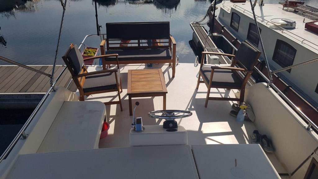 trois chaises et une table à l'arrière d'un bateau dans l'établissement Le Colibri, à Saint-Jean-de-Losne