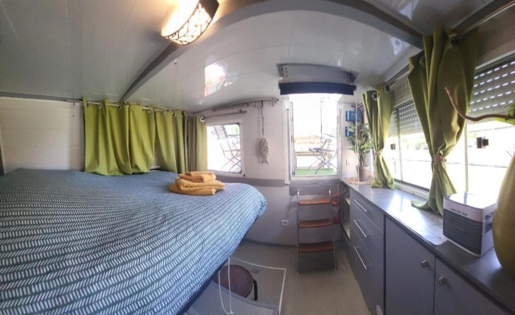 - une petite chambre avec un lit dans un rv dans l'établissement Logement entier sur bateau, à Montech