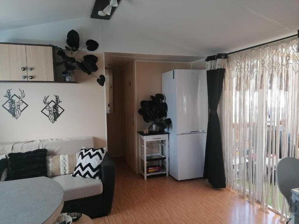 - un salon avec un canapé et un réfrigérateur dans l'établissement MOBILHOME COSY SPACIEUX 42m2, CLIMATISE, TV & LL, 3 chambres, à Vic-la-Gardiole 8 autres photos