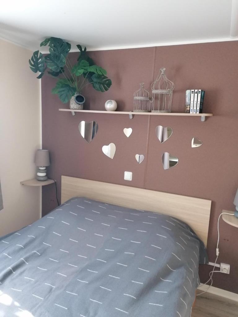 - une chambre dotée d'un lit avec des cœurs sur le mur dans l'établissement MOBILHOME COSY SPACIEUX 42m2, CLIMATISE, TV & LL, 3 chambres, à Vic-la-Gardiole