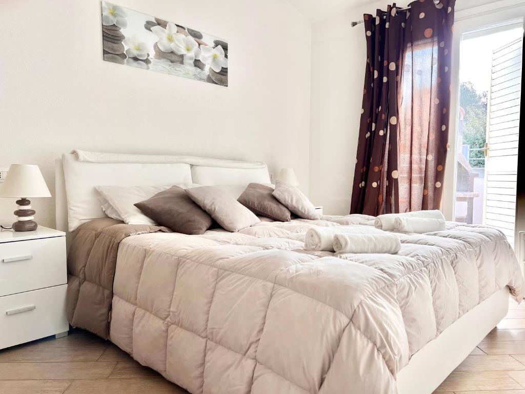 - un lit blanc dans une chambre avec fenêtre dans l'établissement Villa Etienne - Key to Villas, à Valledoria 9 autres photos