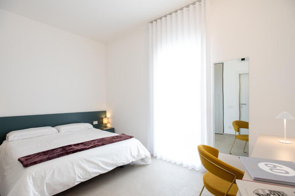 une chambre blanche avec un grand lit et un bureau dans l'établissement Villa Lucia - Piscina Privata Riscaldata, à Marina di Ragusa