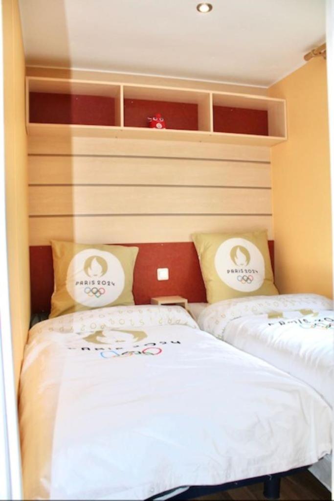 deux lits dans une petite pièce avec dans l'établissement Mobil Home Cosy, à Saint-Chéron