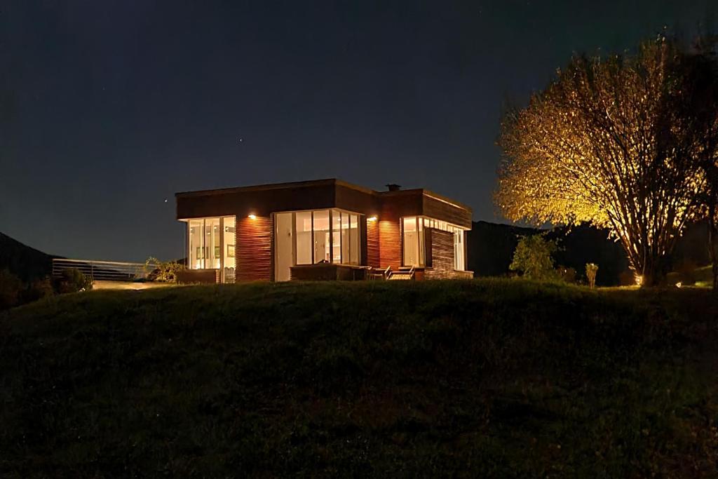 une petite maison sur une colline la nuit dans l'établissement Villa La Betulla, à Cerano d'Intelvi