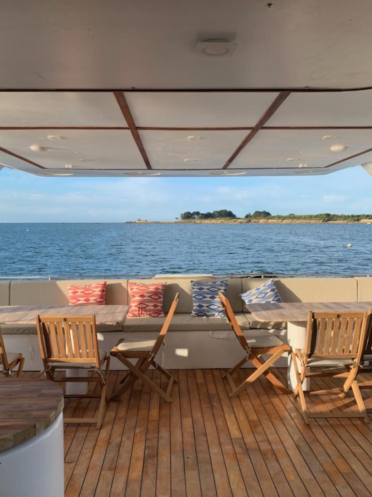 une table et des chaises sur le pont d'un bateau dans l'établissement Valmarelo Maxi Catamaran, à Saint-Philibert