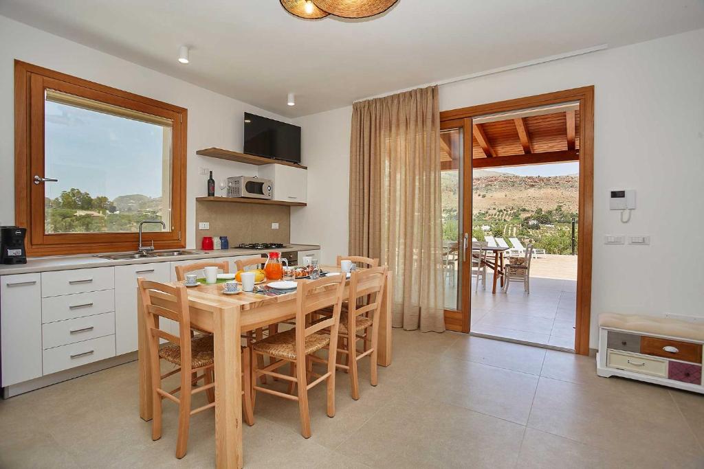 - une cuisine avec une table et des chaises en bois dans l'établissement Villa Ninfa, à Castellammare del Golfo