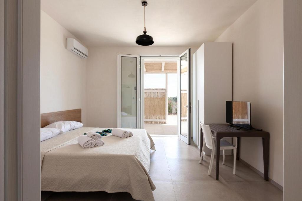 une chambre avec deux lits, un bureau et une télévision dans l'établissement Villa La Reimunda, à Otrante