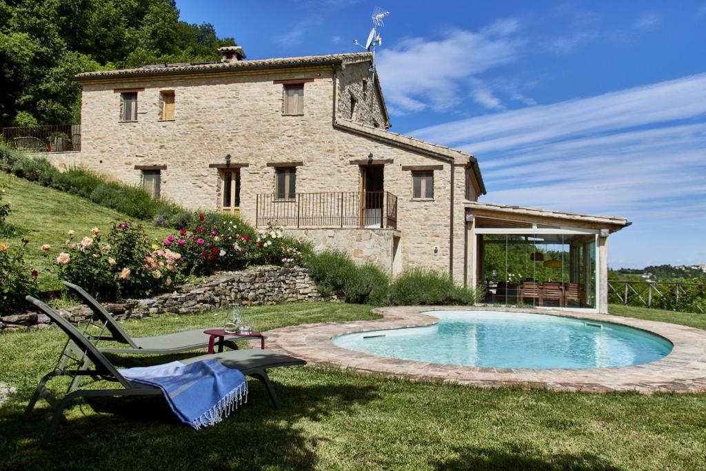 une vieille maison en pierre avec une piscine dans la cour dans l'établissement Refugium VERITAS - entire Villa with Pool, à Cupramontana