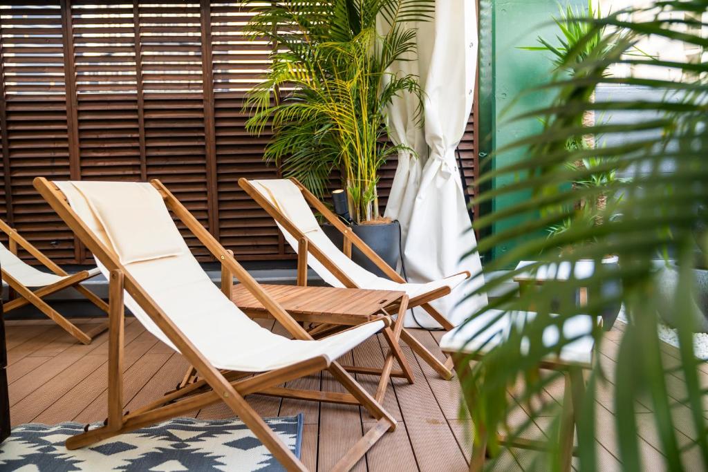 2 chaises et une plante sur une terrasse couverte dans l'établissement Hotel Bali An Resort Shinjuku Forest, à Tokyo