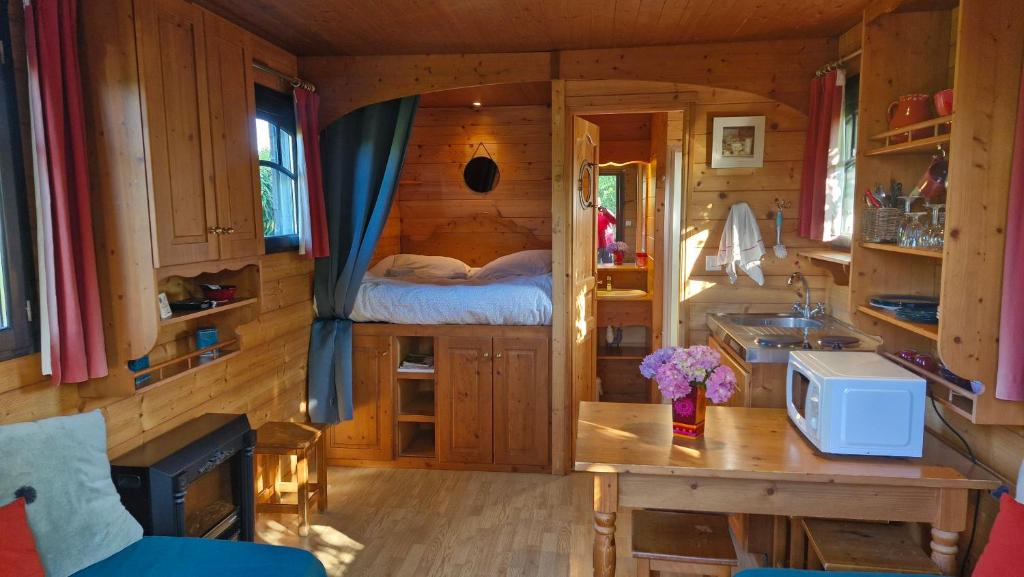 une petite chambre avec un lit dans une cabane en rondins dans l'établissement Gites de la Ferme de l'Eglise, à Fatouville-Grestain