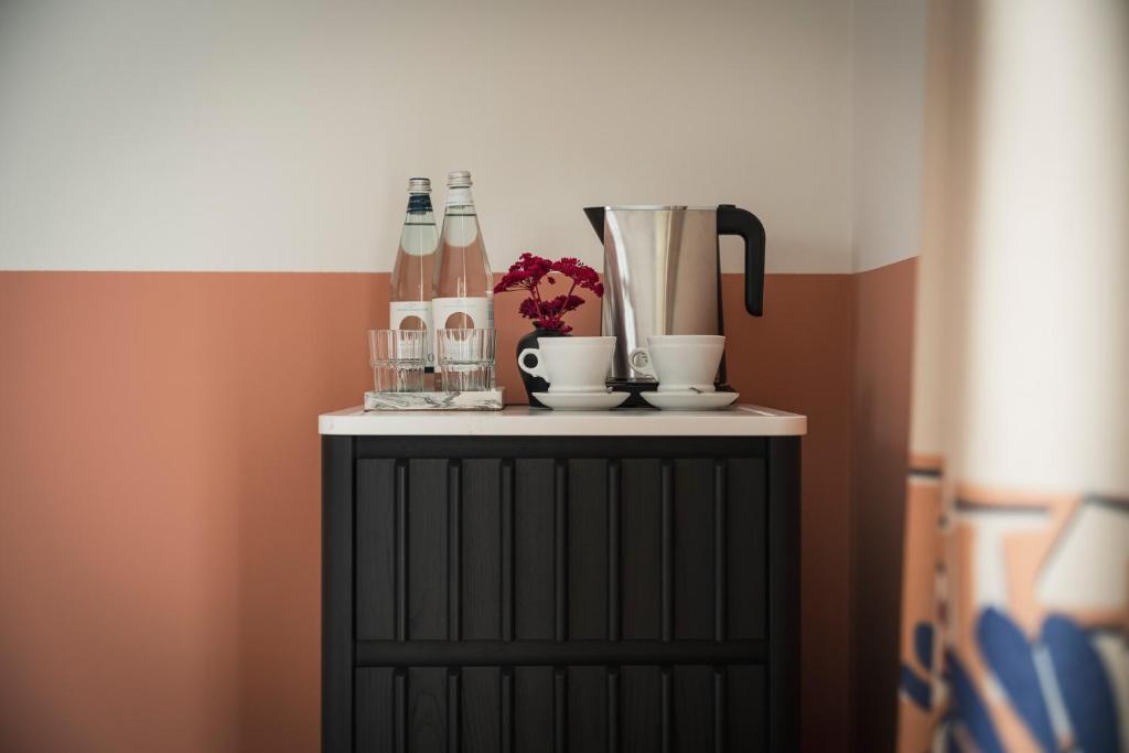 une armoire noire avec des bouteilles et des boissons. dans l'établissement DuoMo Hotel, à Rimini