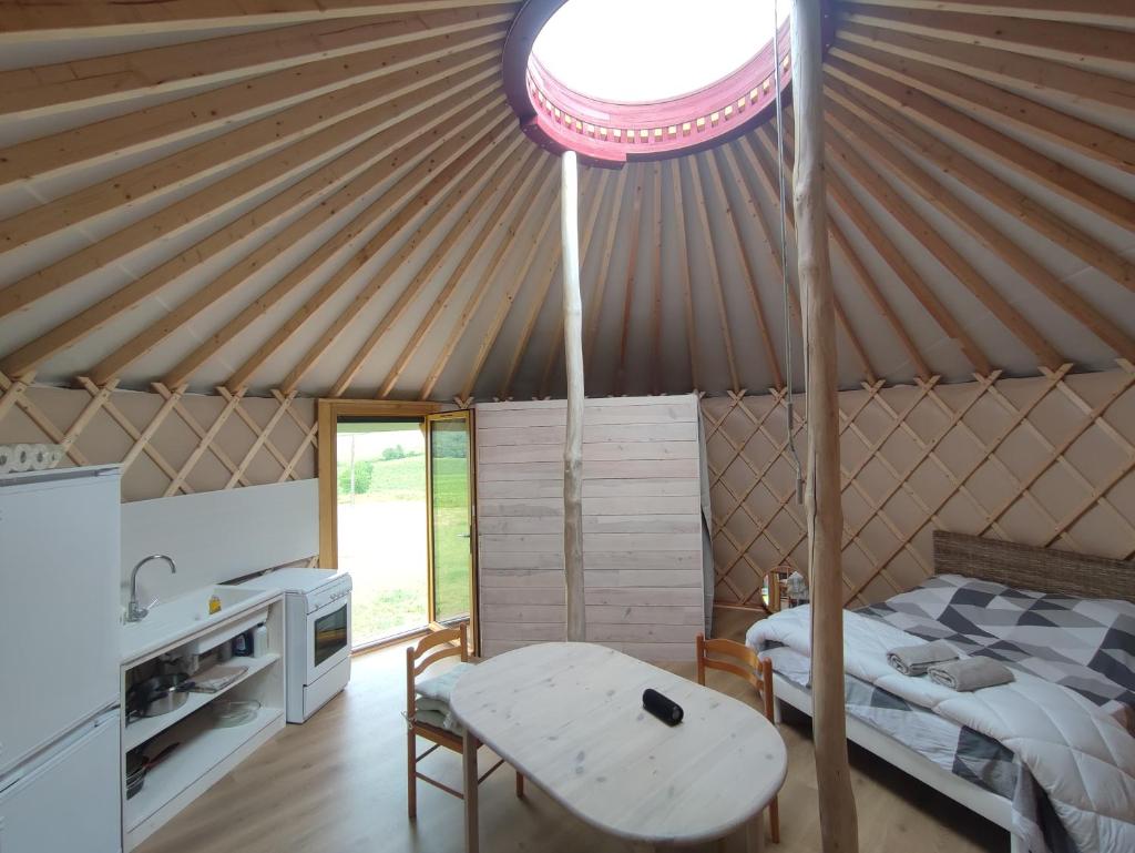 - une chambre avec un lit et une table dans une yourte dans l'établissement Chaleureuse yourte a la campagne, à Mourens