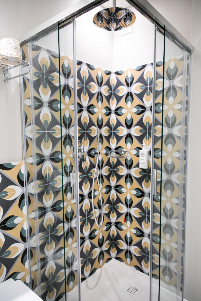 une cabine de douche avec un rideau de douche à motifs dans l'établissement Hotel Cristallo, à Senigallia 52 autres photos