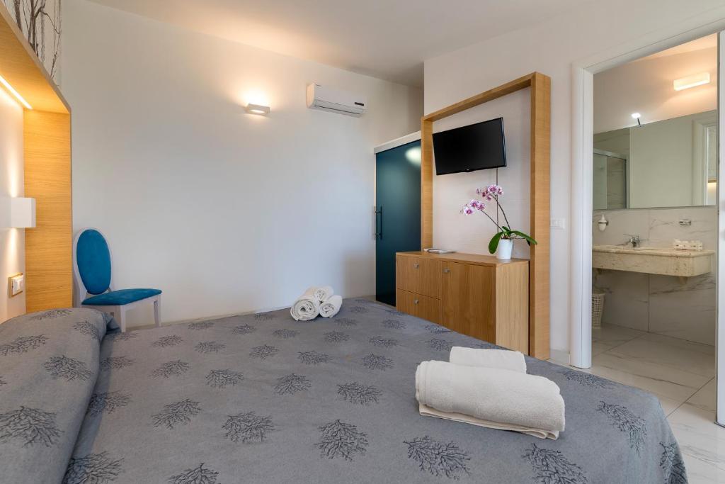 une chambre avec un grand lit et une salle de bain dans l'établissement Hotel Villaggio Stromboli, à Santa Domenica