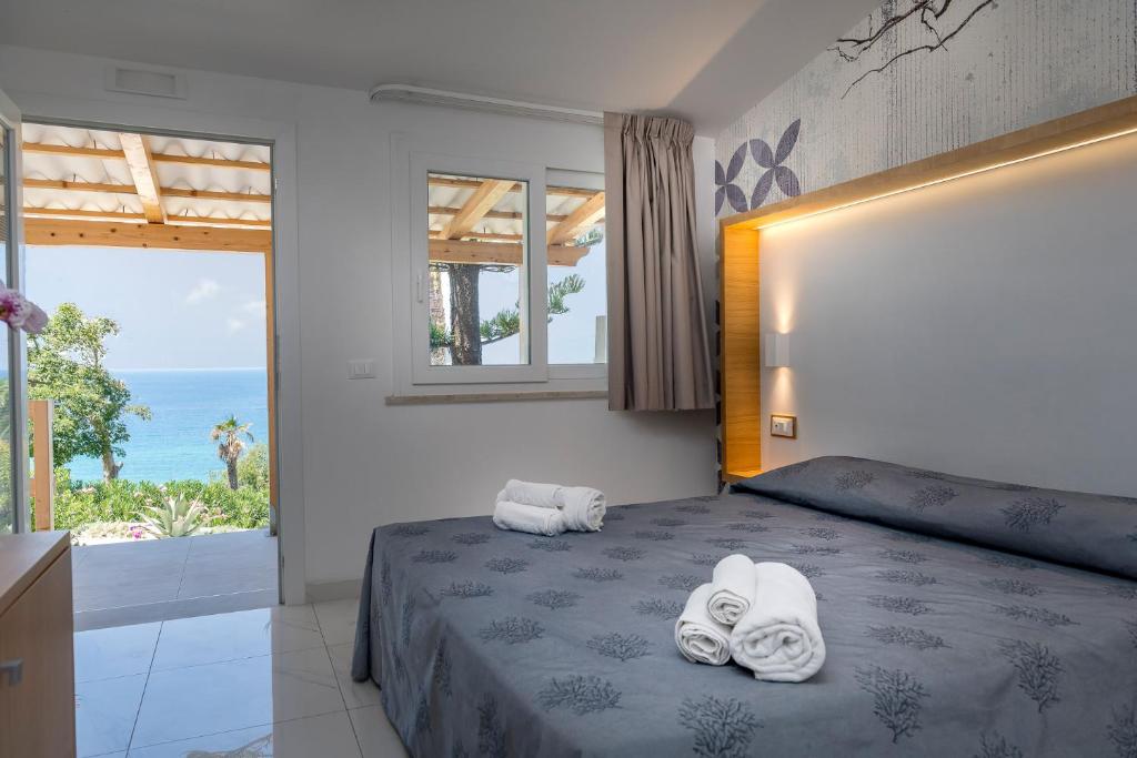 une chambre avec un lit et une vue sur l'océan dans l'établissement Hotel Villaggio Stromboli, à Santa Domenica