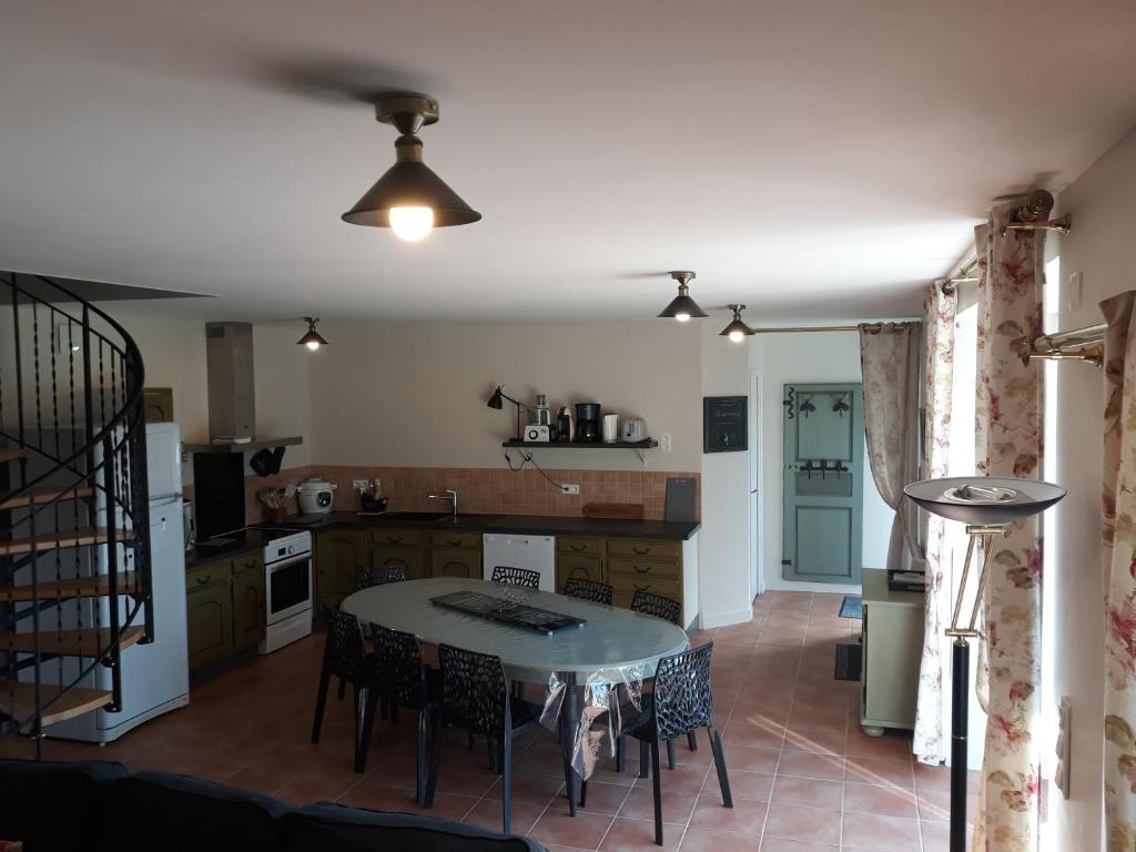 une cuisine et un salon avec une table et des chaises dans l'établissement Gite de la Houssière, à Joué-du-Bois