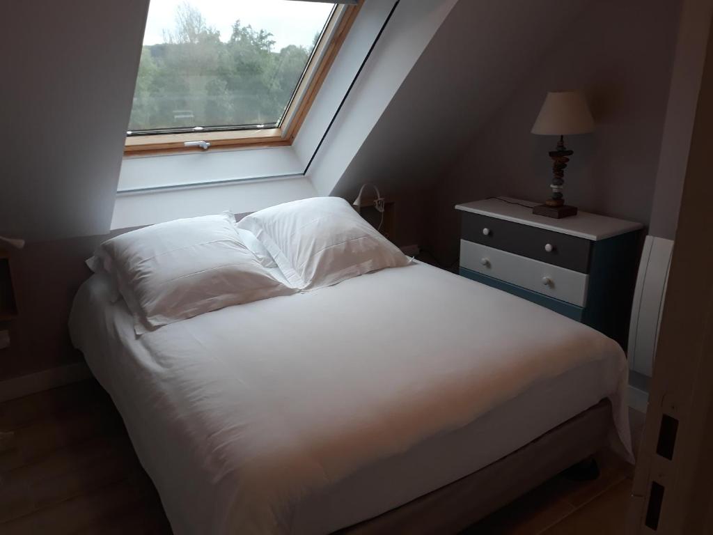 une chambre avec un lit blanc et une fenêtre dans l'établissement Gite de la Houssière, à Joué-du-Bois