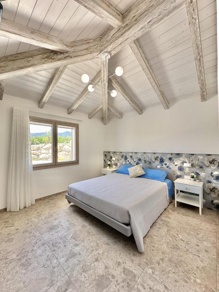 une chambre avec un grand lit avec des oreillers bleus dans l'établissement Villa Smeraldo Castiadas, à Castiadas