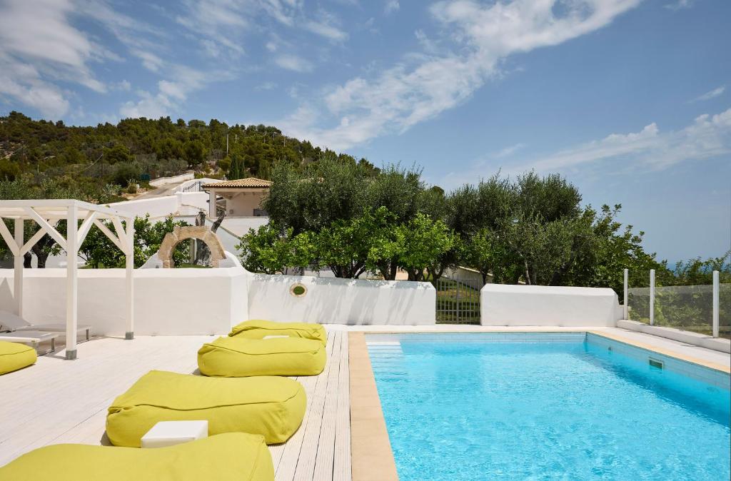 une piscine avec des chaises longues et une piscine dans l'établissement La Locanda Del Carrubo, à Mattinata