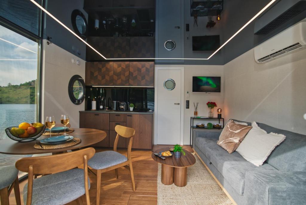 un salon avec un canapé et une table dans l'établissement Houseboat by Noma, à Saint-Étienne