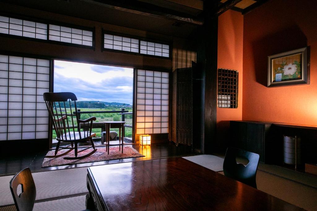 une chambre avec une chaise et une table avec une fenêtre dans l'établissement Isamikan, à Nakagawa