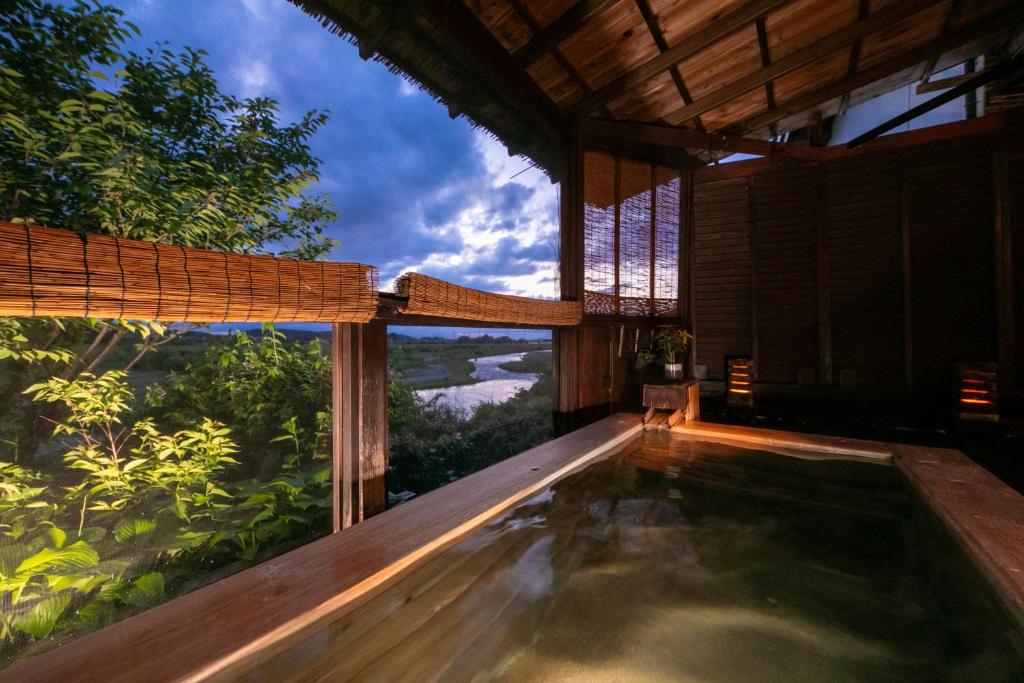 une piscine dans une maison avec vue sur la forêt dans l'établissement Isamikan, à Nakagawa
