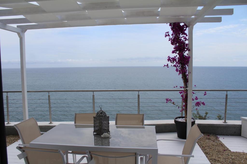 une table et des chaises sur un balcon donnant sur l'océan dans l'établissement Conca Verde c15-Beach front little villa POOL SPA BEACH, à Marina dʼAndora